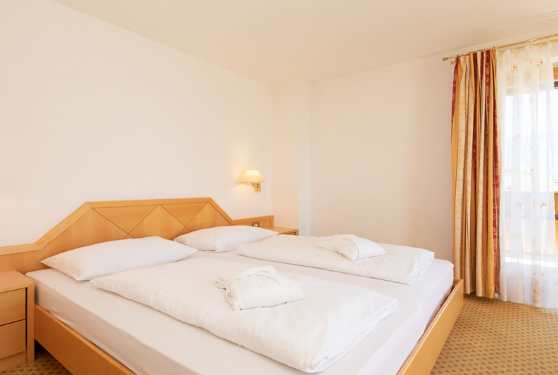 Bedroom with double bed and balcony in the Hirzer Suite