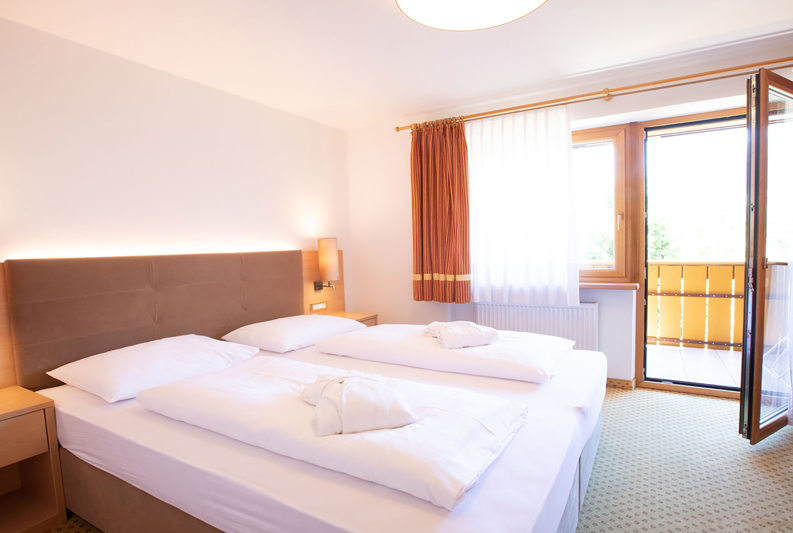 Bedroom with double bed and balcony of the Mutspitz Superior Suite